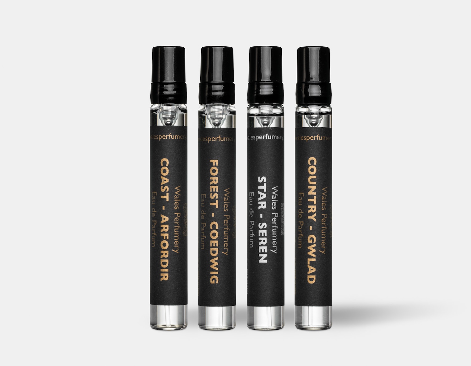 Four 7.5ml perfume bottle stood up next to each other, they have black labels
