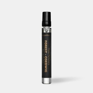 Black travel size perfume atomiser with a black cap and label, standing upright on a plain light grey background.