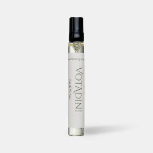 Travel size perfume atomiser with a black cap and cream label, standing upright on a plain light grey background.
