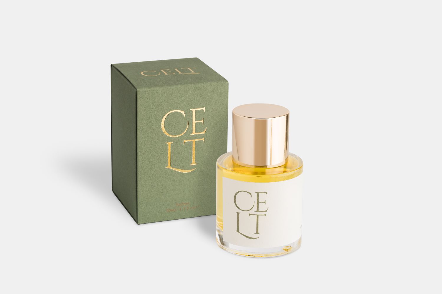 a bottle of parfum, the bottle has a cream label saying celt, and a glossy gold cap. it is next to a green box also saying celt in gold print