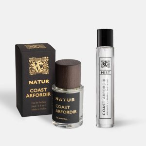 A Wales Perfumery Natur Coast Arfordir 30ml Eau de Parfum in a clear glass bottle with a dark wooden cap, alongside its black and gold gift box, and a slim Coast Arfordir Mist featuring bergamot, seaweed and driftwood, on a light grey background.
