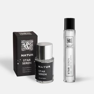 A Wales Perfumery Natur Star Seren 30ml Eau de Parfum in a clear glass bottle with a polished silver cap, alongside its black and silver gift box decorated with stars, and a slim Star Seren Mist featuring yuzu, green tea and jasmine, on a light grey background.