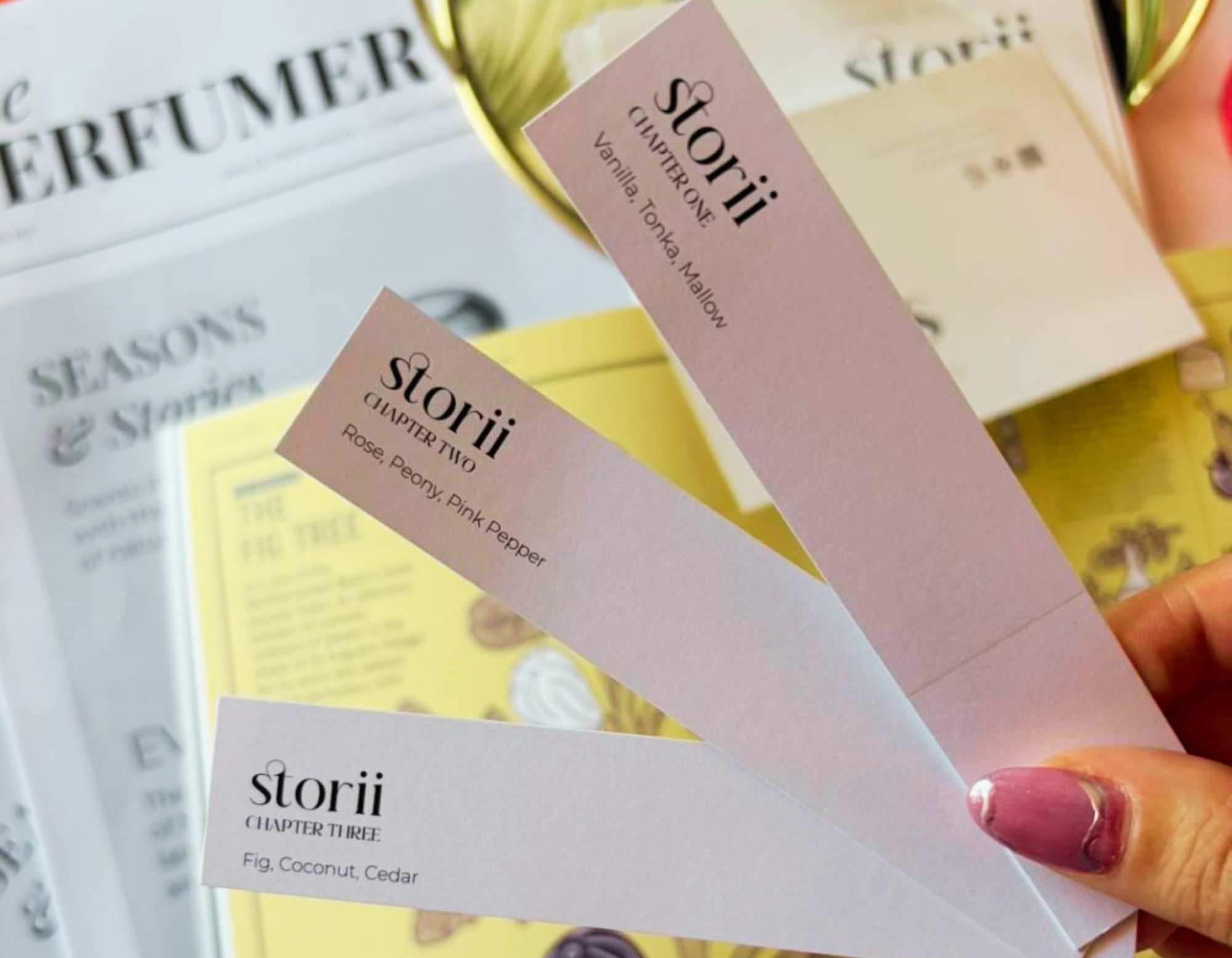 Storii by Wales Perfumery fragrance wardrobe scent strips for Chapter One, Two and Three fanned out alongside the Perfumer's Post