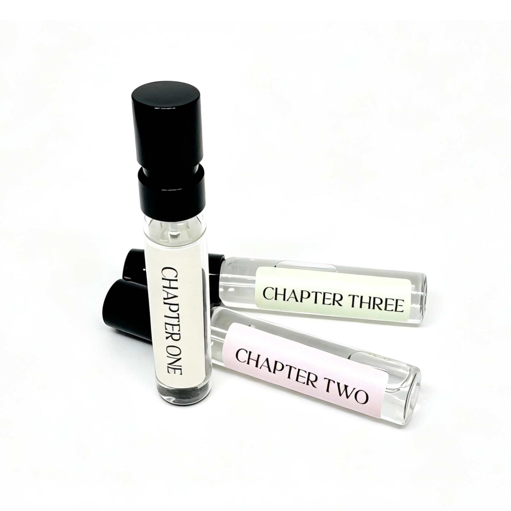 Three Storii perfume sample vials, Chapter One, Chapter Two and Chapter Three, leaning together on a white background