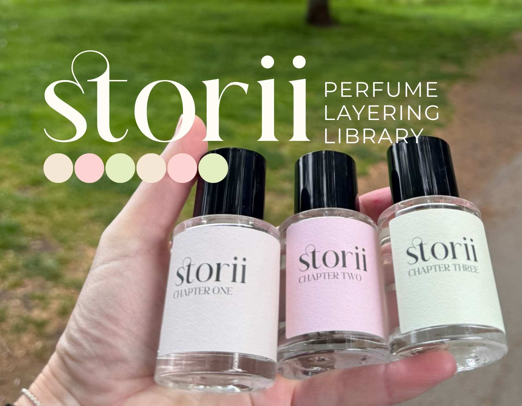 Three Storii fragrance bottles held in a hand outdoors, with green foliage in the background and the Storii perfume layering library logo