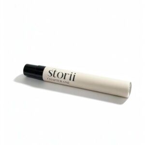 Storii Chapter One 7ml perfume spray, cream label with black cap, lying diagonally on a white background