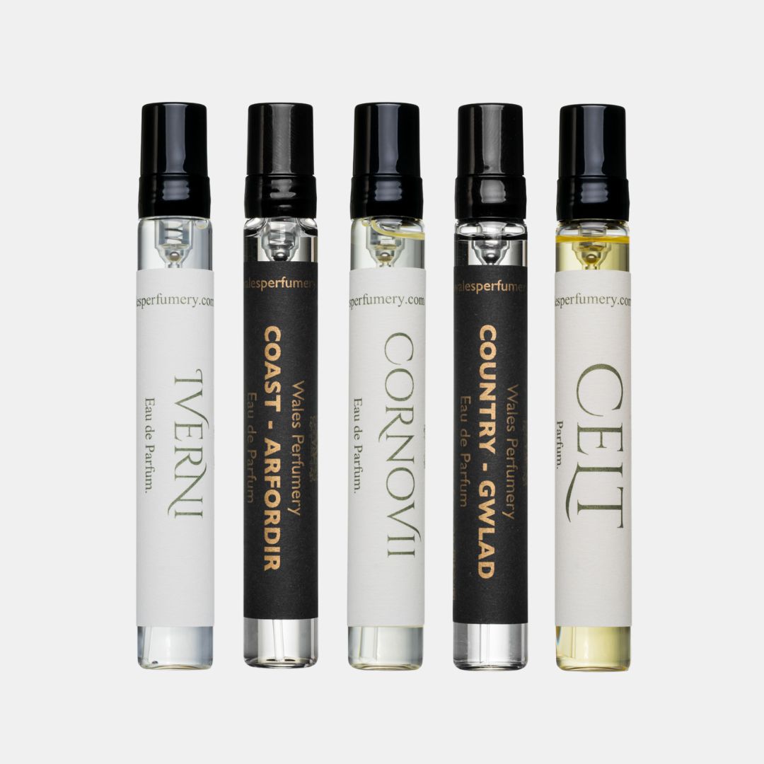 Five Wales Perfumery sample vials with black spray caps on a light grey background: Coast – Arfordir and Country – Gwlad in black-and-gold labels with a white-labelled Cornovii & Iverni Eau de Parfum and Celt Parfum